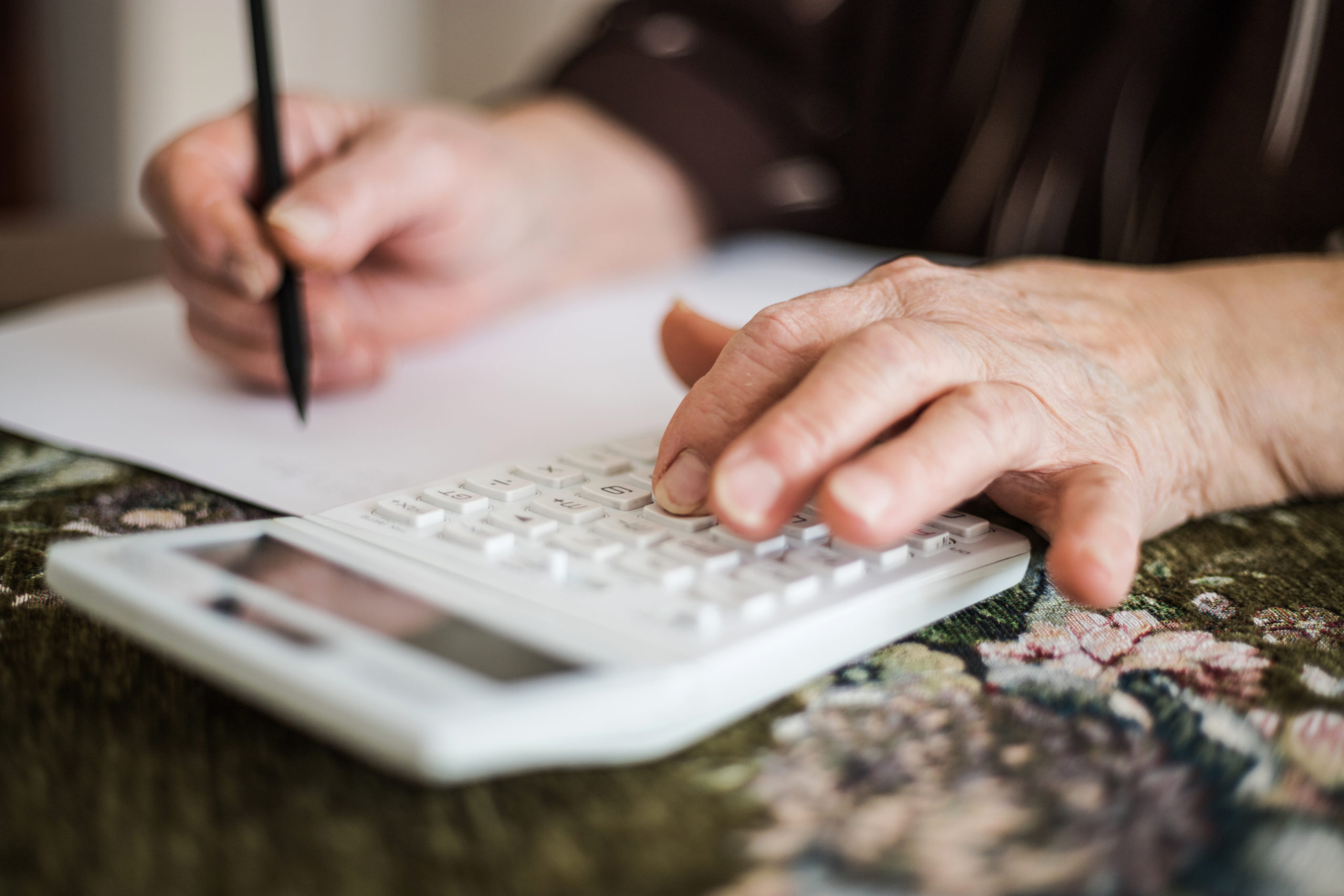 close up of older woman with calculator