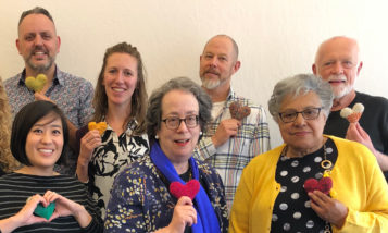 Members of the Community Living Campaign board of directors holding knitted hearts